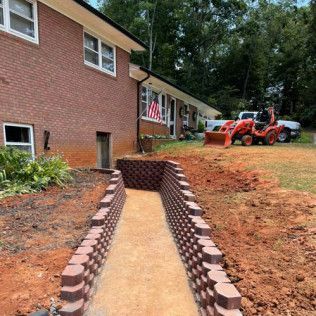 A tractor is parked in front of a brick house.