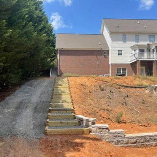 A house with a driveway and stairs leading up to it.