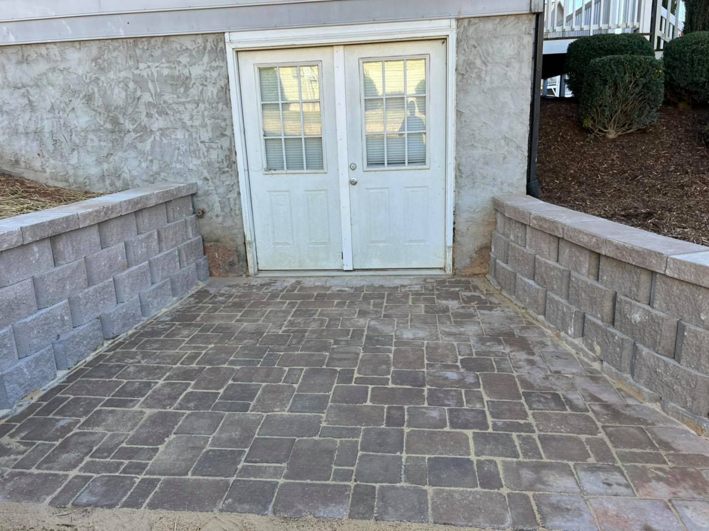 A brick walkway leading to a garage with a white door.