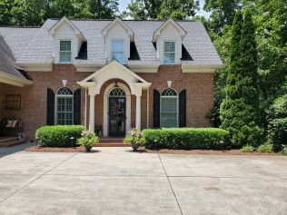 A large brick house with a gray roof and black shutters