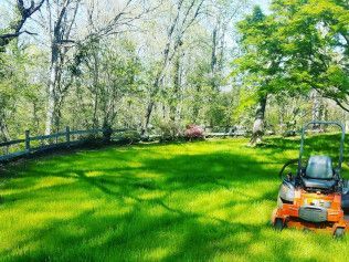A lawn mower is sitting in the middle of a lush green field.