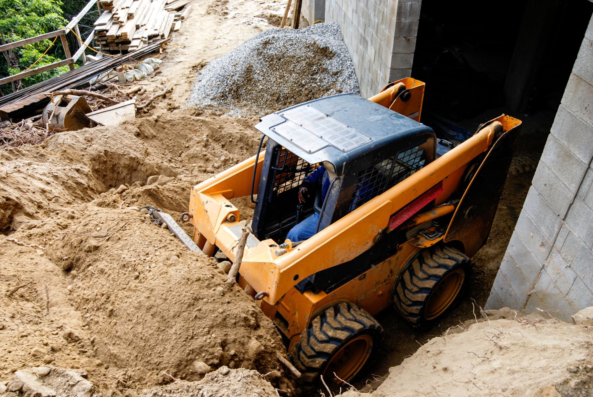 A small bulldozer is moving dirt on a construction site.