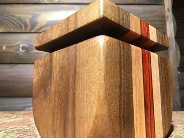 A wooden box with a lid is sitting on a table.