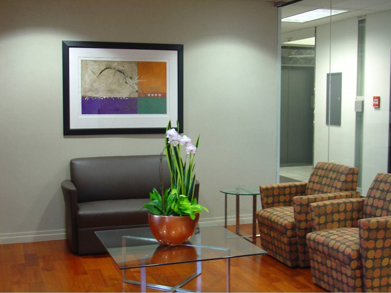 A living room with a couch and chairs and a picture on the wall