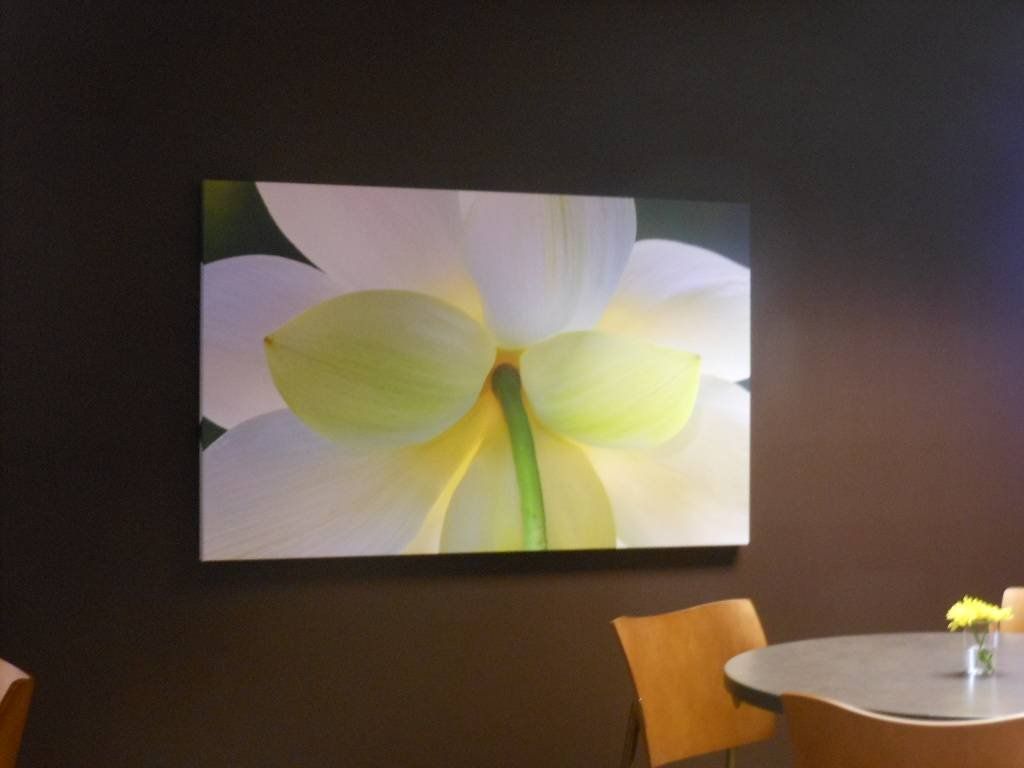 A painting of a flower hangs above a table and chairs