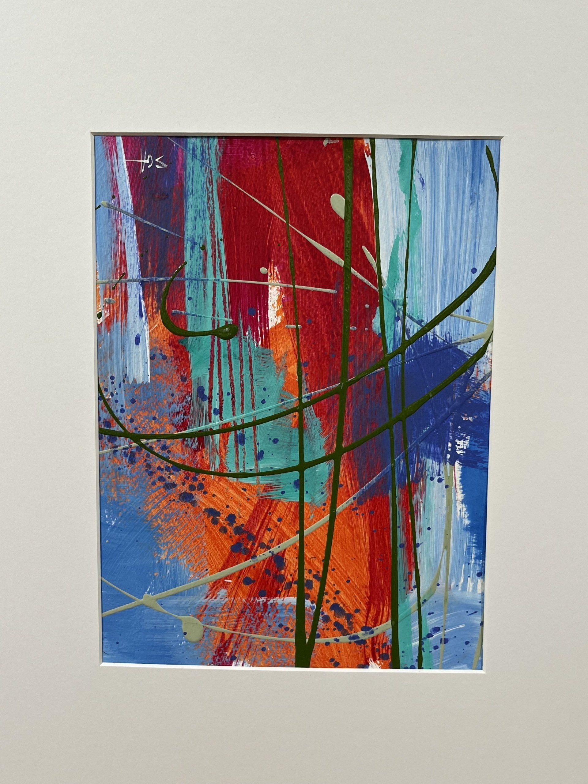 A colorful abstract painting in a white frame