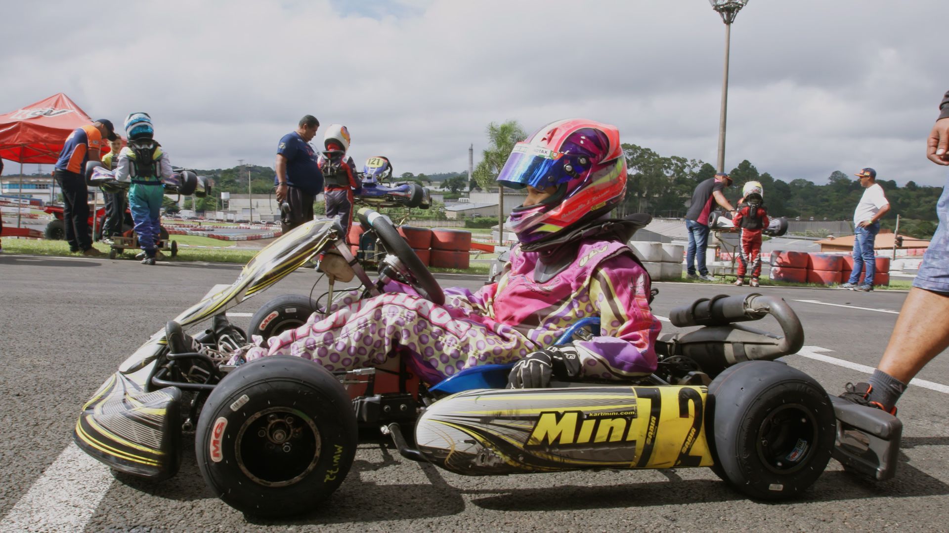 A person is sitting in a go kart on a track.