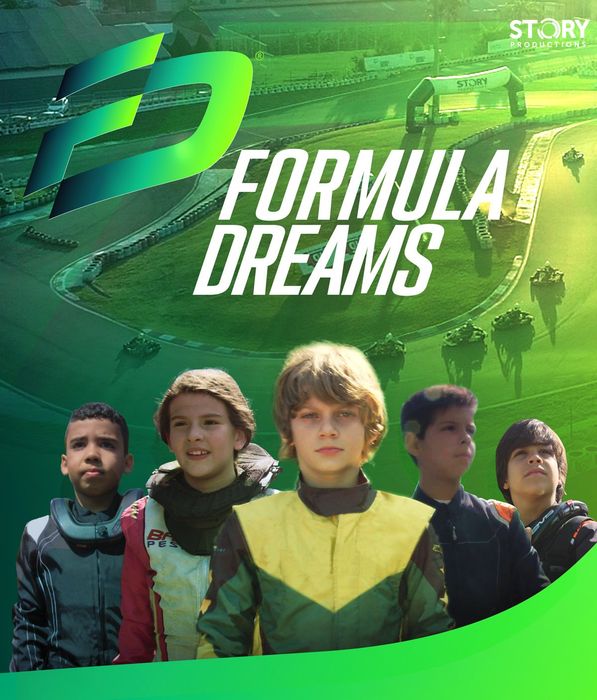 A group of young boys are standing next to each other in front of a race track.