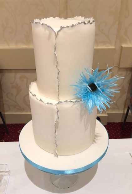 A tall 2-tier cake with pale blue accents.