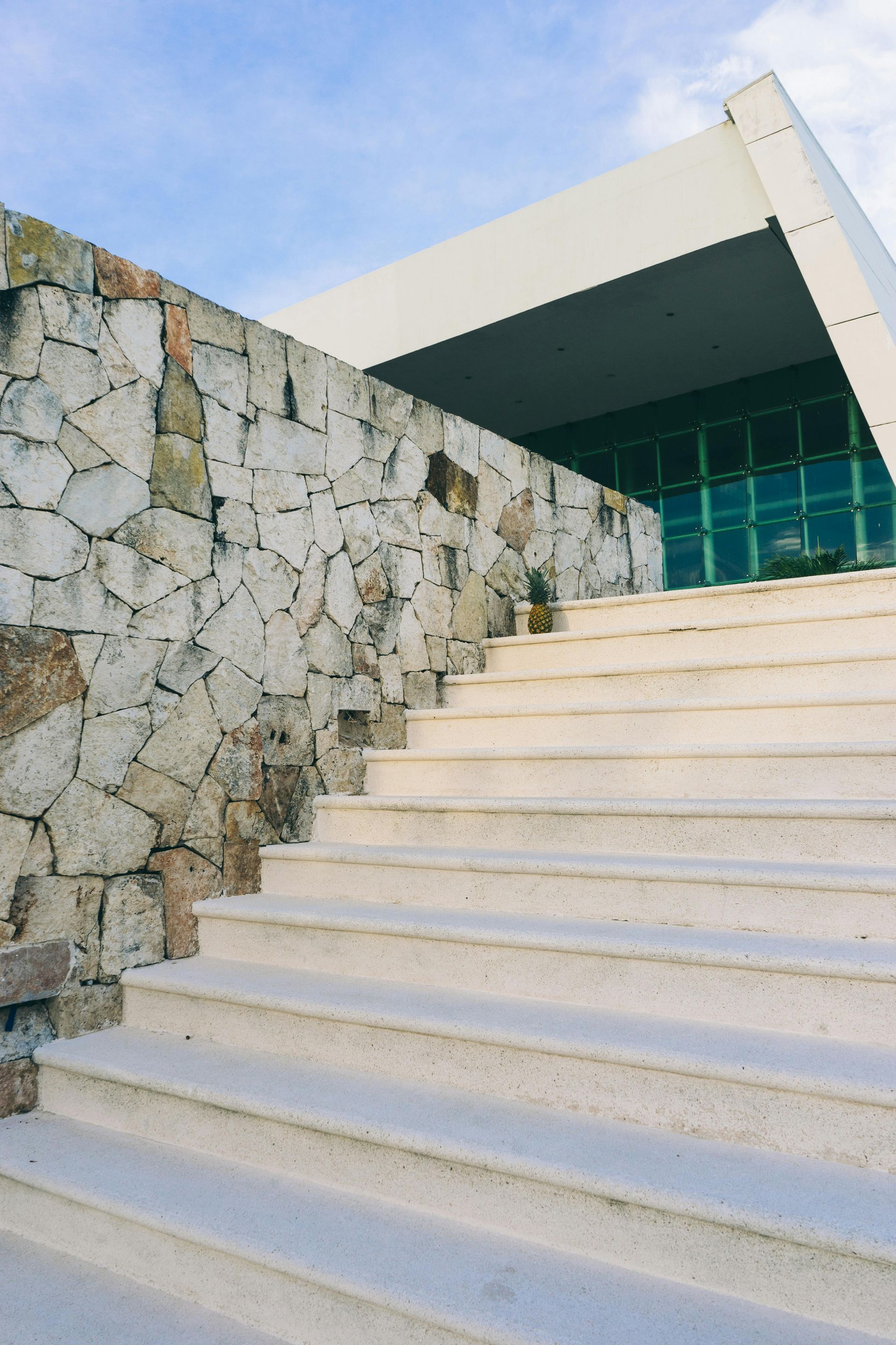 A set of stairs leading up to a building with a stone wall.