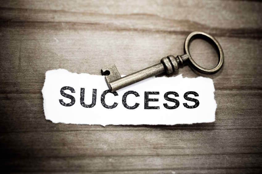 a key is sitting on a piece of paper that says success