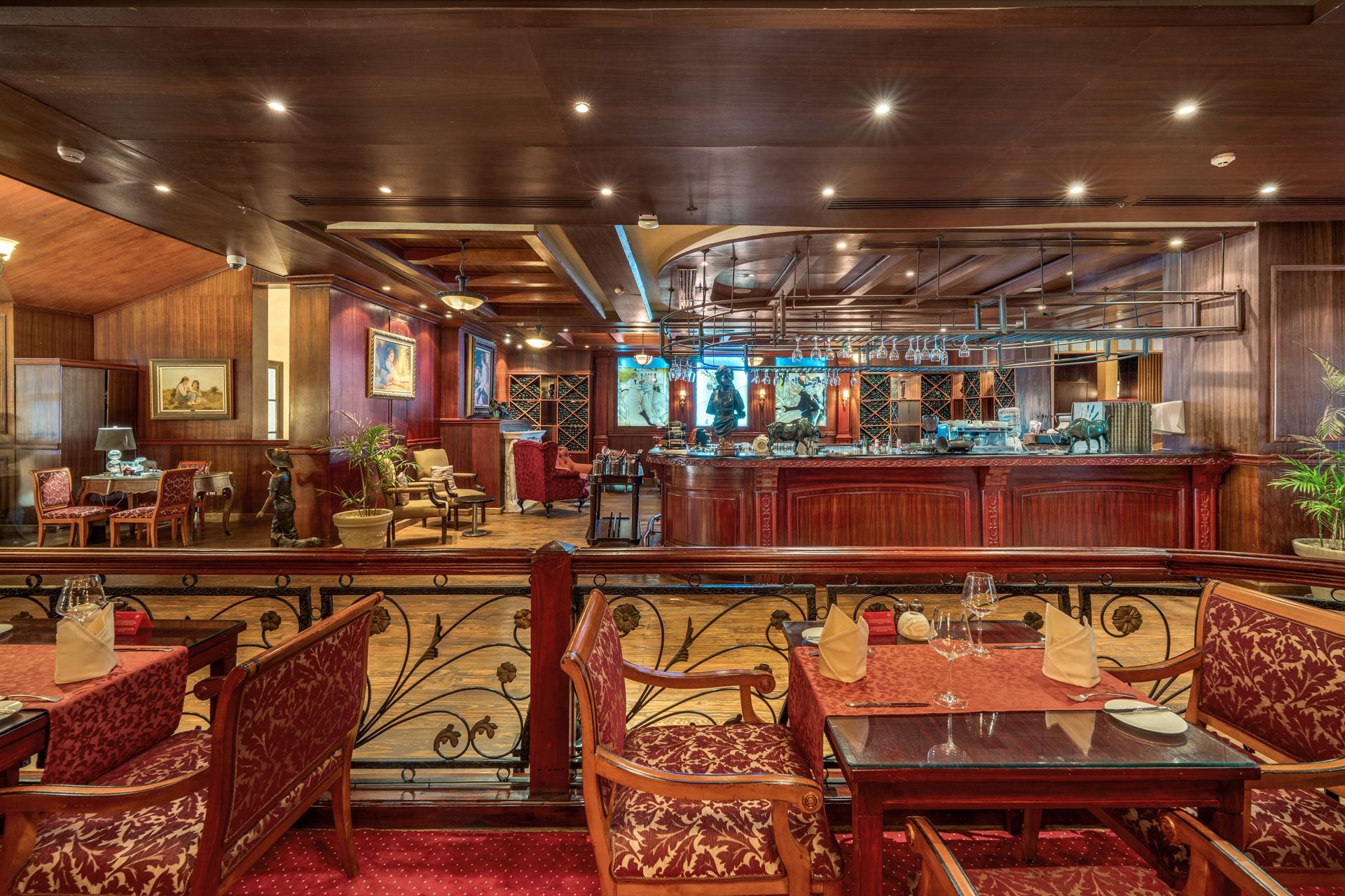 Restaurant interior with tables, bar, and red and wood decor.