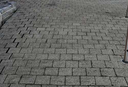 Graues Asphaltschindeldach mit einigen Wölbungen.