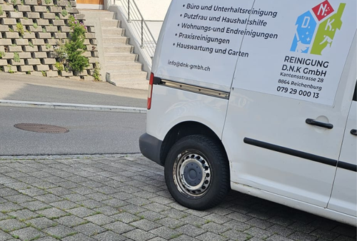Weißer Reinigungswagen auf einer Kopfsteinpflasterstraße geparkt, im Hintergrund eine Treppe.
