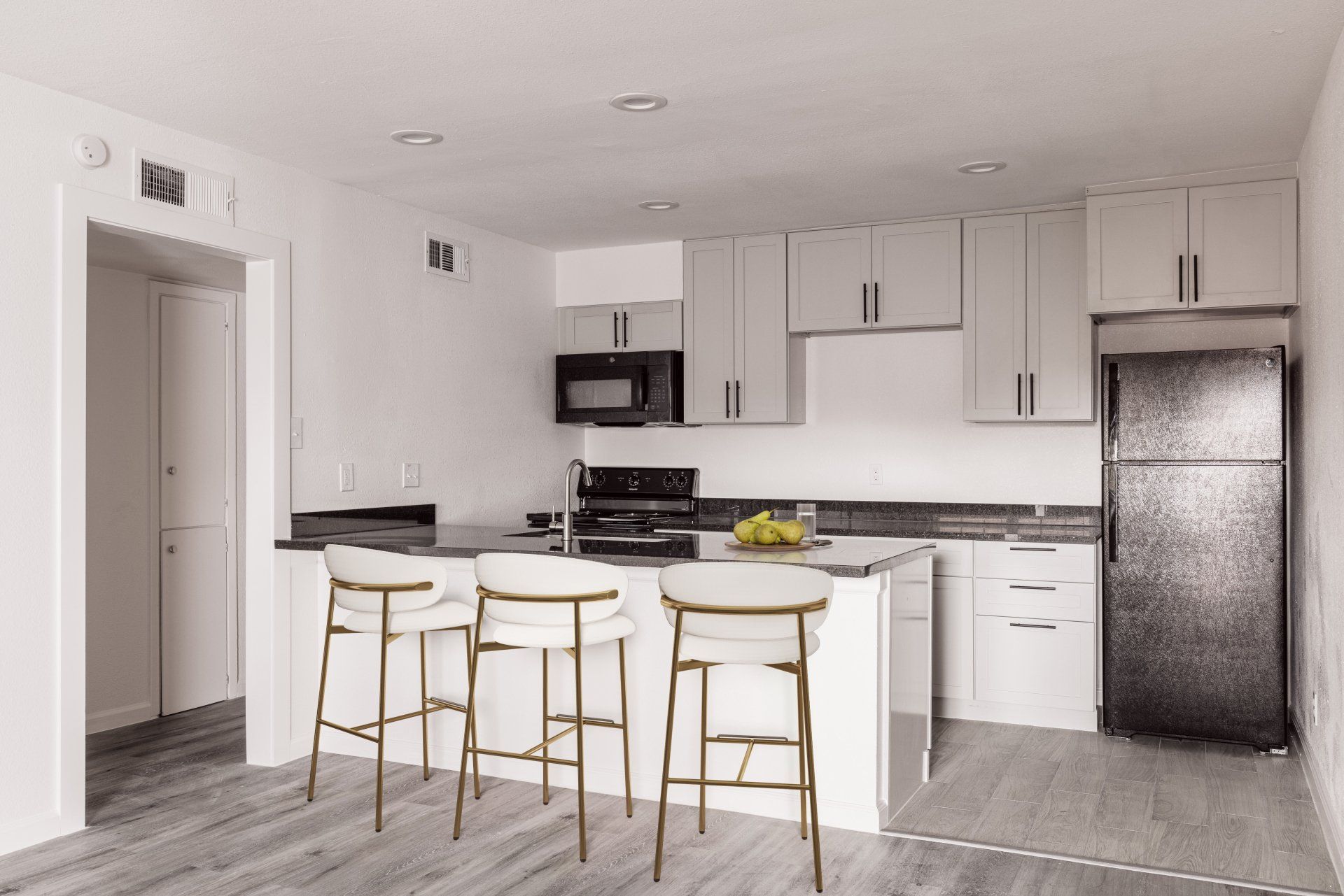 Houston Apartment featuring a gray and white kitchen with a central island and bar stools.