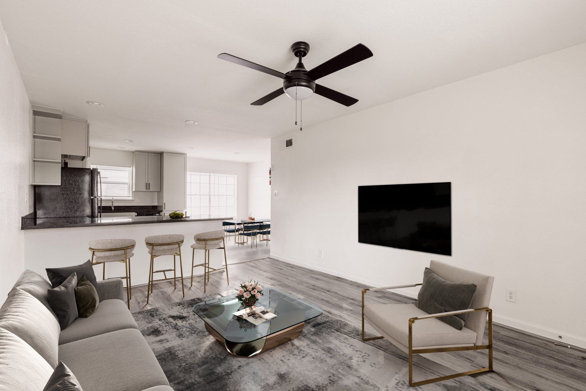 Spacious living room in Houston apartments, showcasing a living room and kitchen area with bar stools.