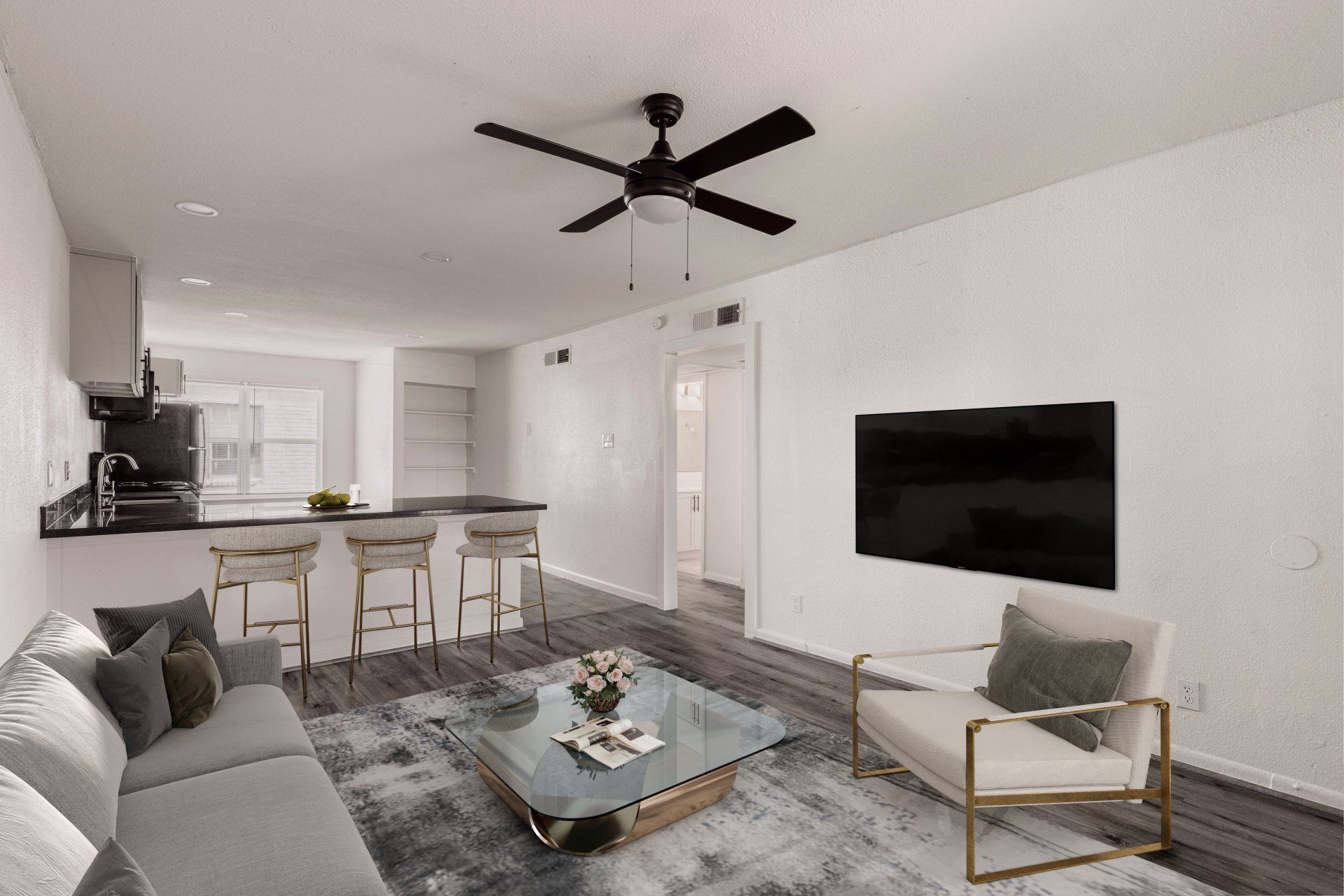 a stylish living room and kitchen area with a ceiling fan in Memorial Houston Apartment for rent.