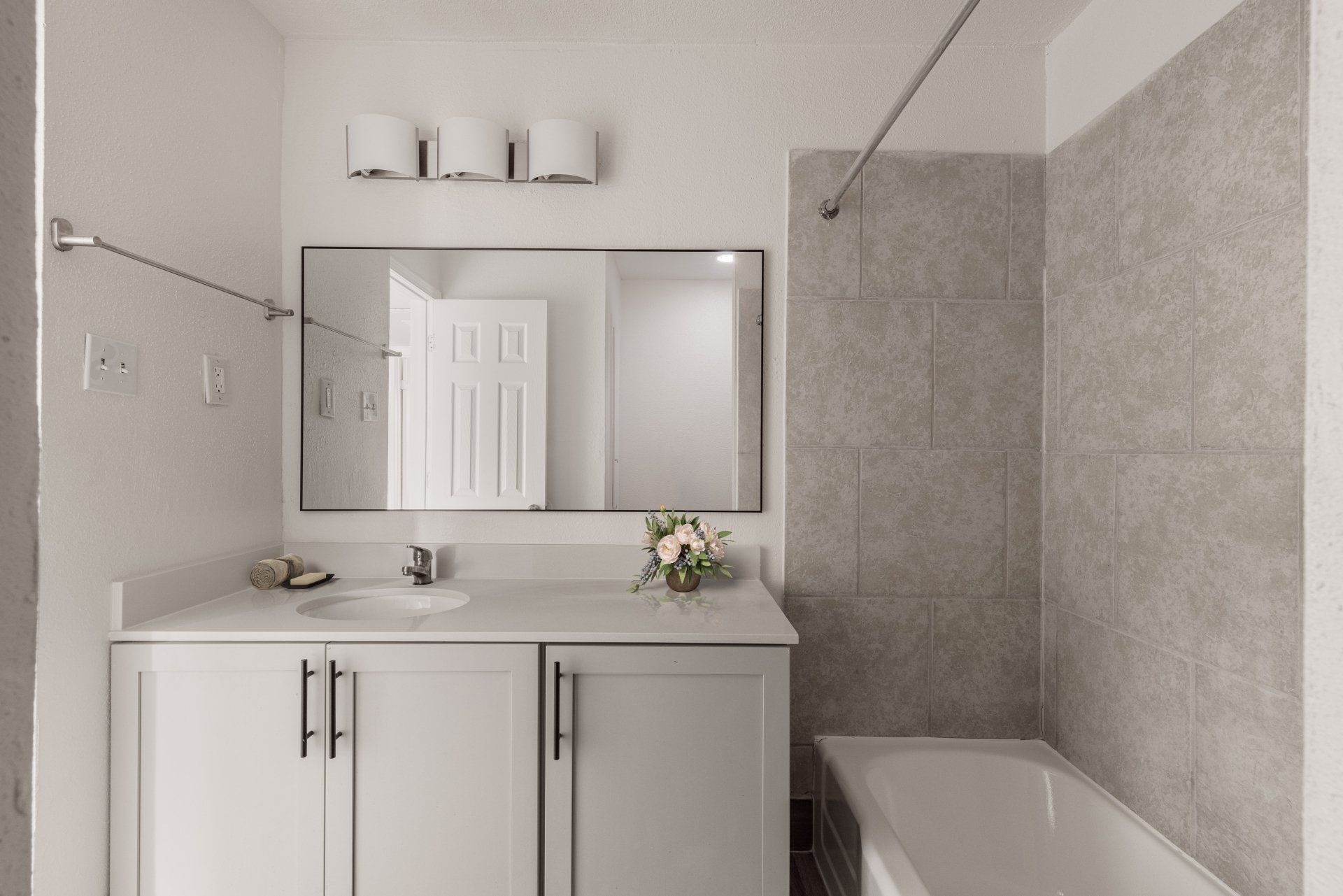 Stylish bathroom with white vanity and new cabinets in Gia Memorial apartments for rent in Houston.