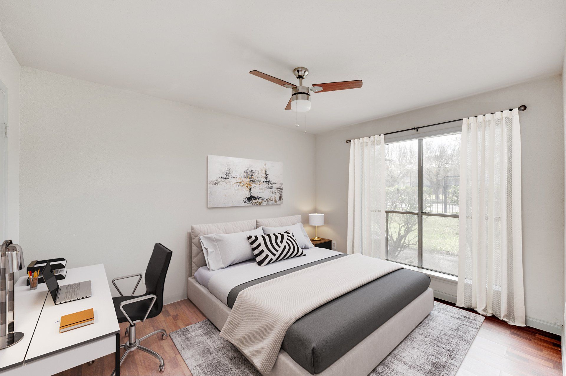 Modern bedroom at GIA Westchase, with a desk and ceiling fan, showcasing apartments in Westchase District Houston TX.