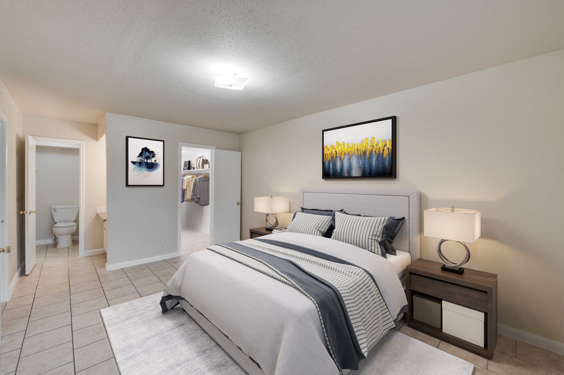 Modern bedroom in a Houston, TX apartment, featuring tiled floors and direct access to the en-suite bathroom and closet.