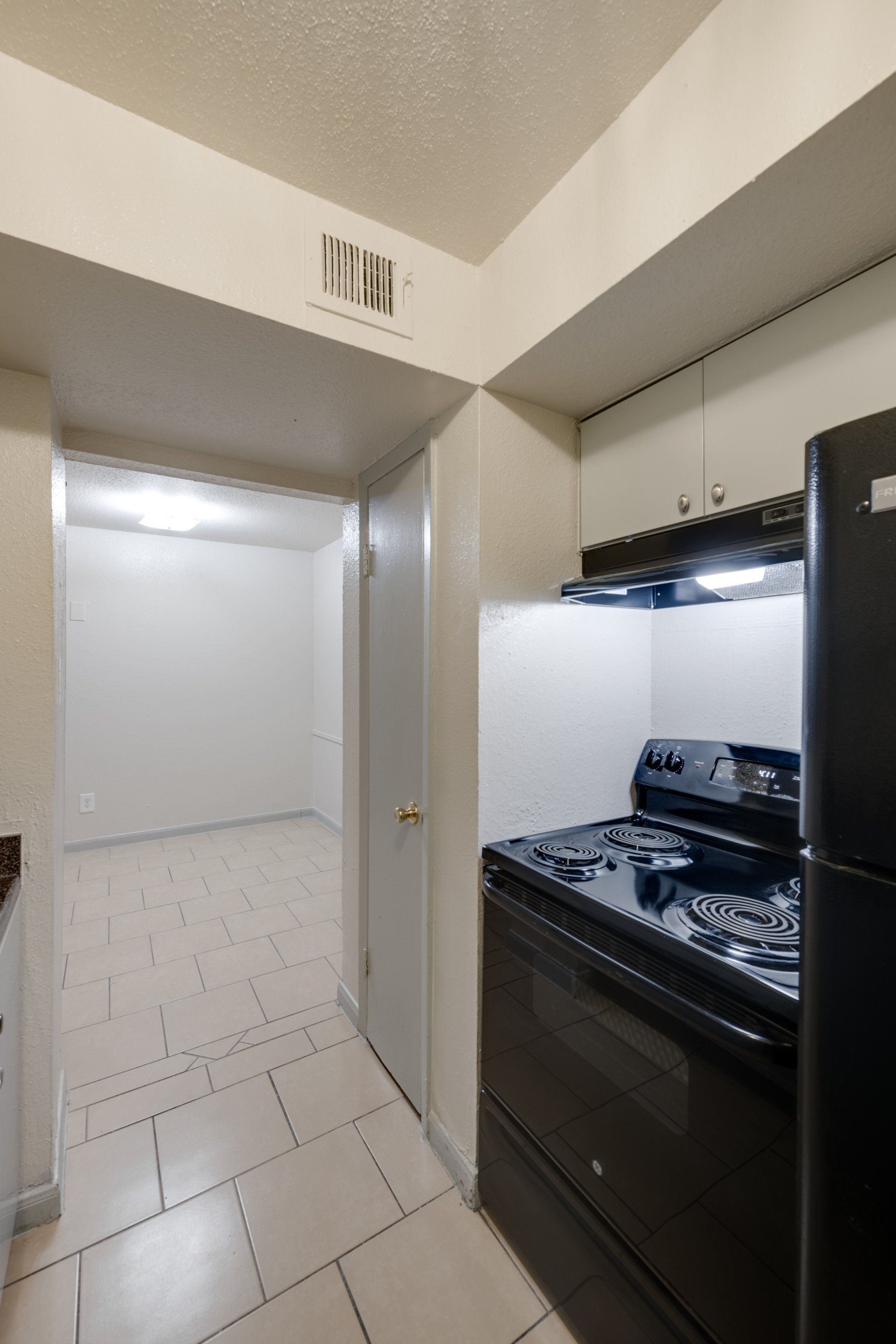 Fully-equipped kitchen in Houston apartments for rent, with black appliances and dining area.