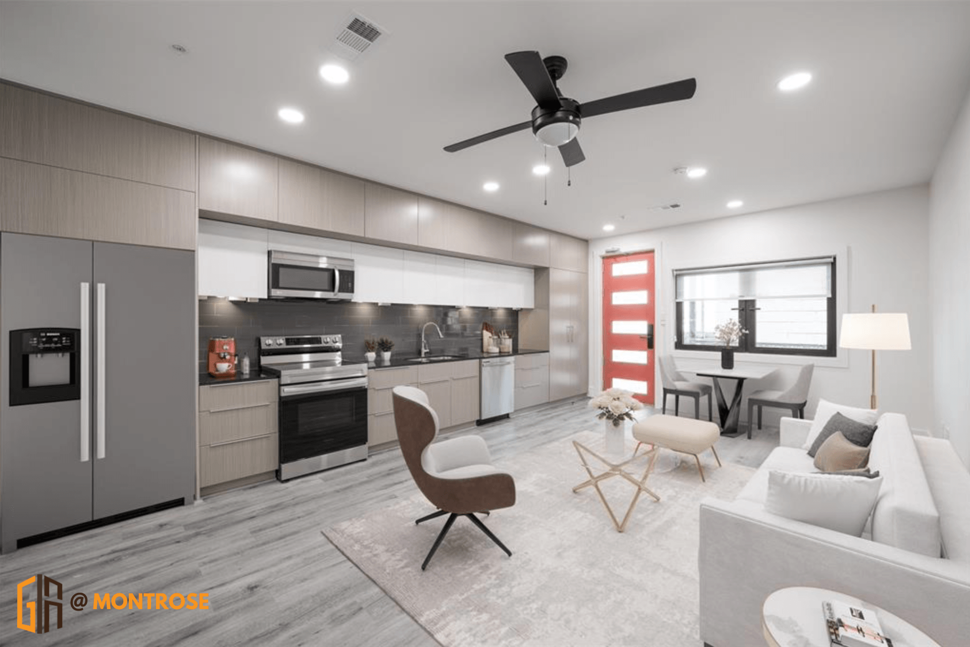 Modern kitchen in a Montrose Houston apartment with stainless steel appliances, sleek cabinets, and a red door.