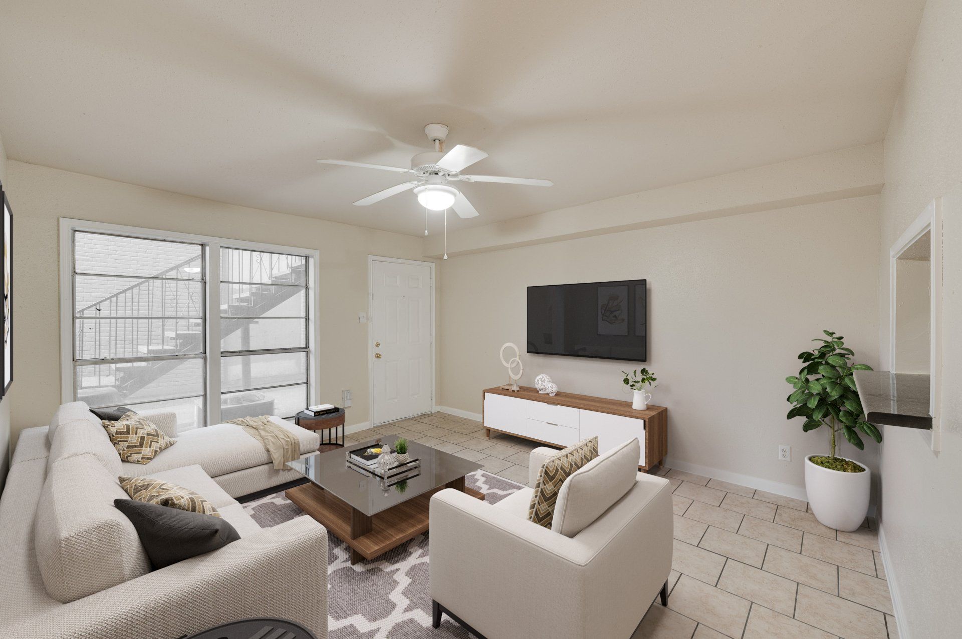 Modern living room in Houston apartment for rent. Natural light, sectional, glass table, wall TV.