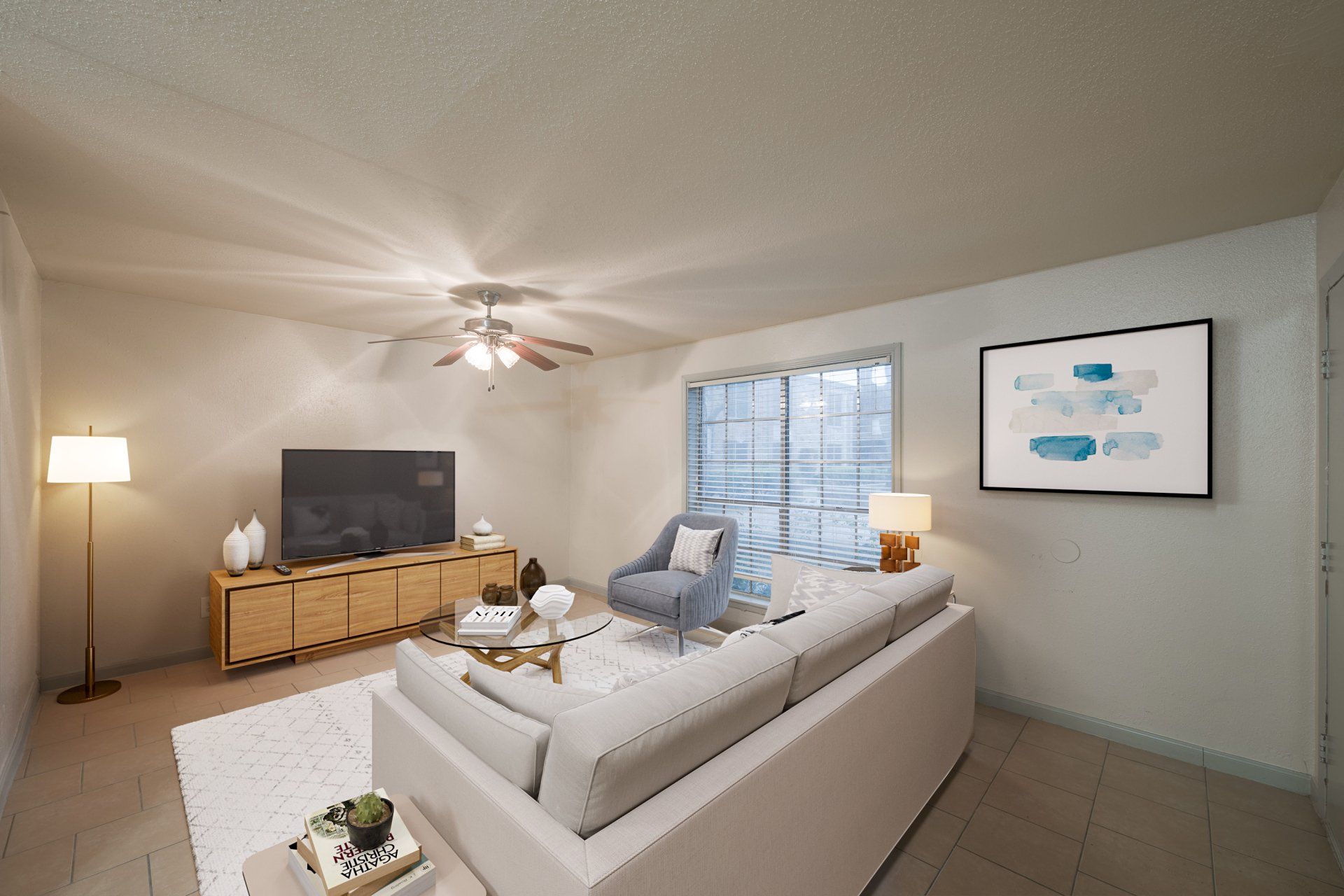 Living room of Houston apartment with abundant natural light, modern sectional, stylish decor.