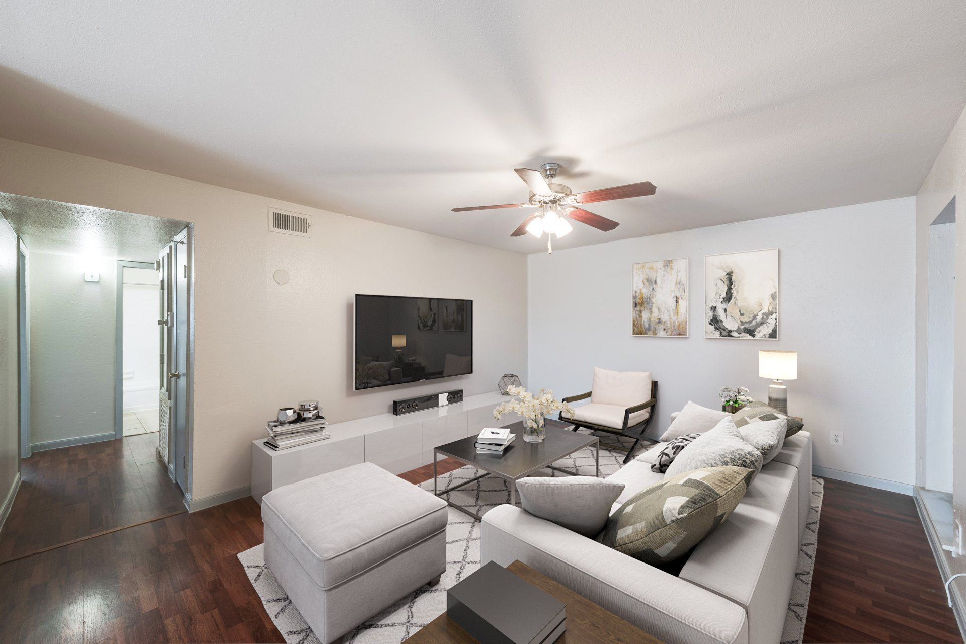 Living room of Houston apartment with abundant natural light, modern sectional, stylish decor.