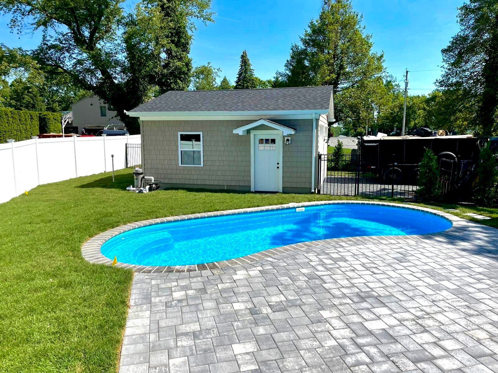A small house with a swimming pool in front of it.