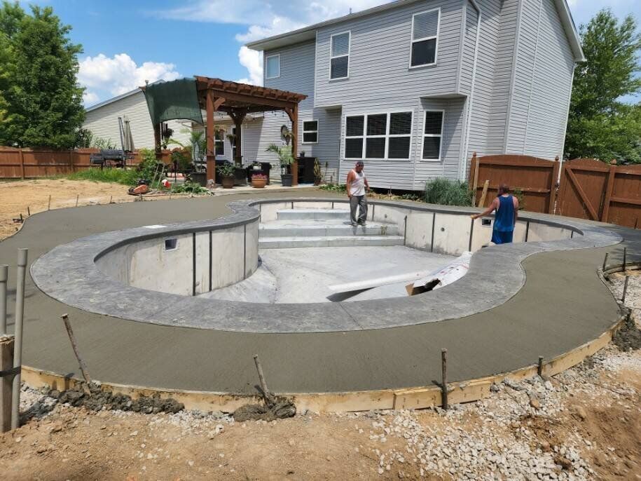 A swimming pool is being built in the backyard of a house.