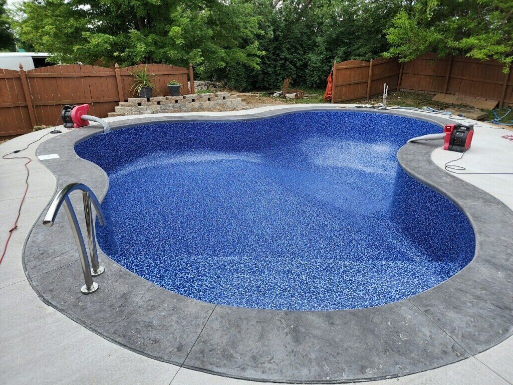 A large blue swimming pool is being built in a backyard.