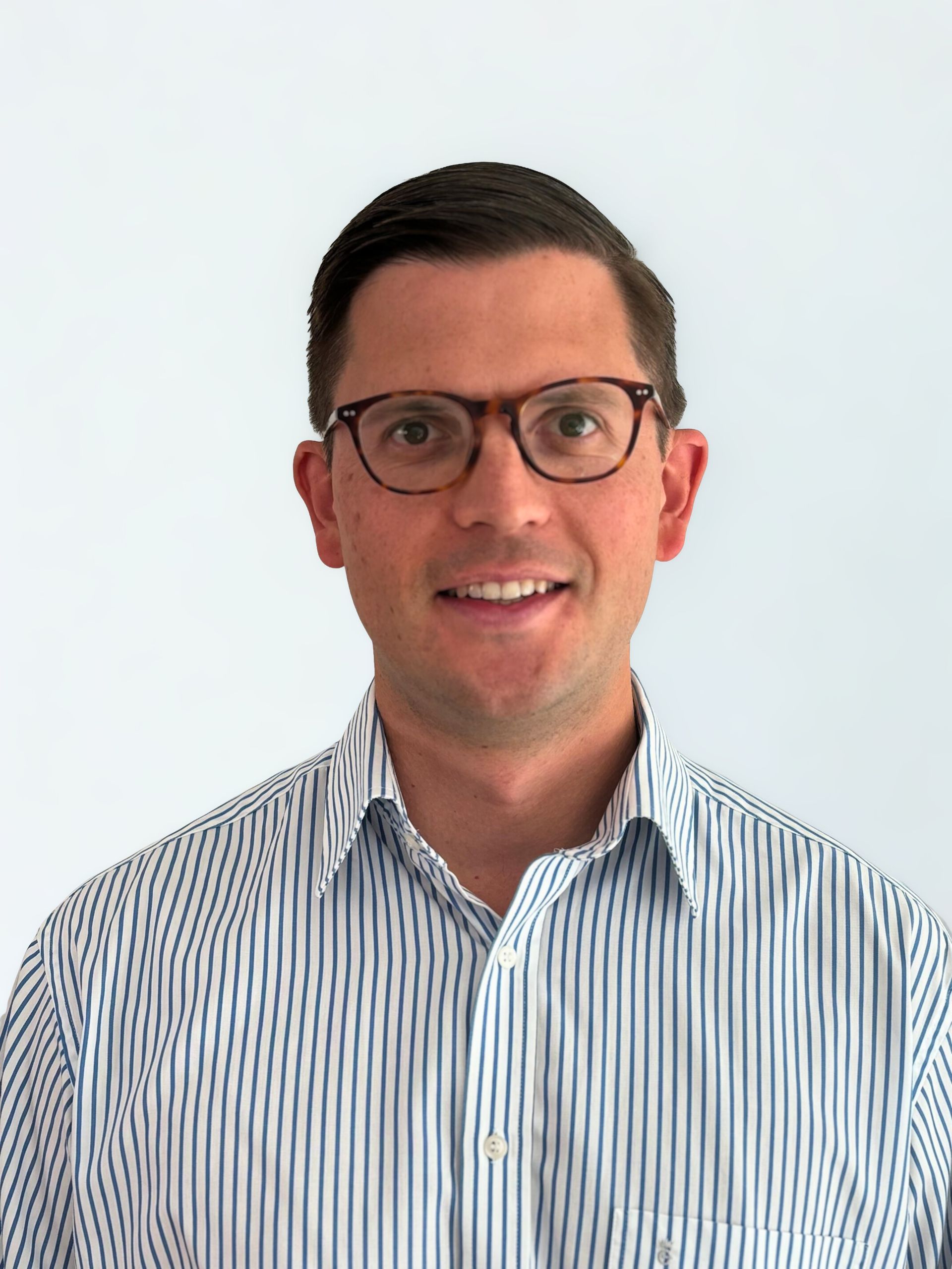 Man wearing glasses and striped shirt, smiling at camera.