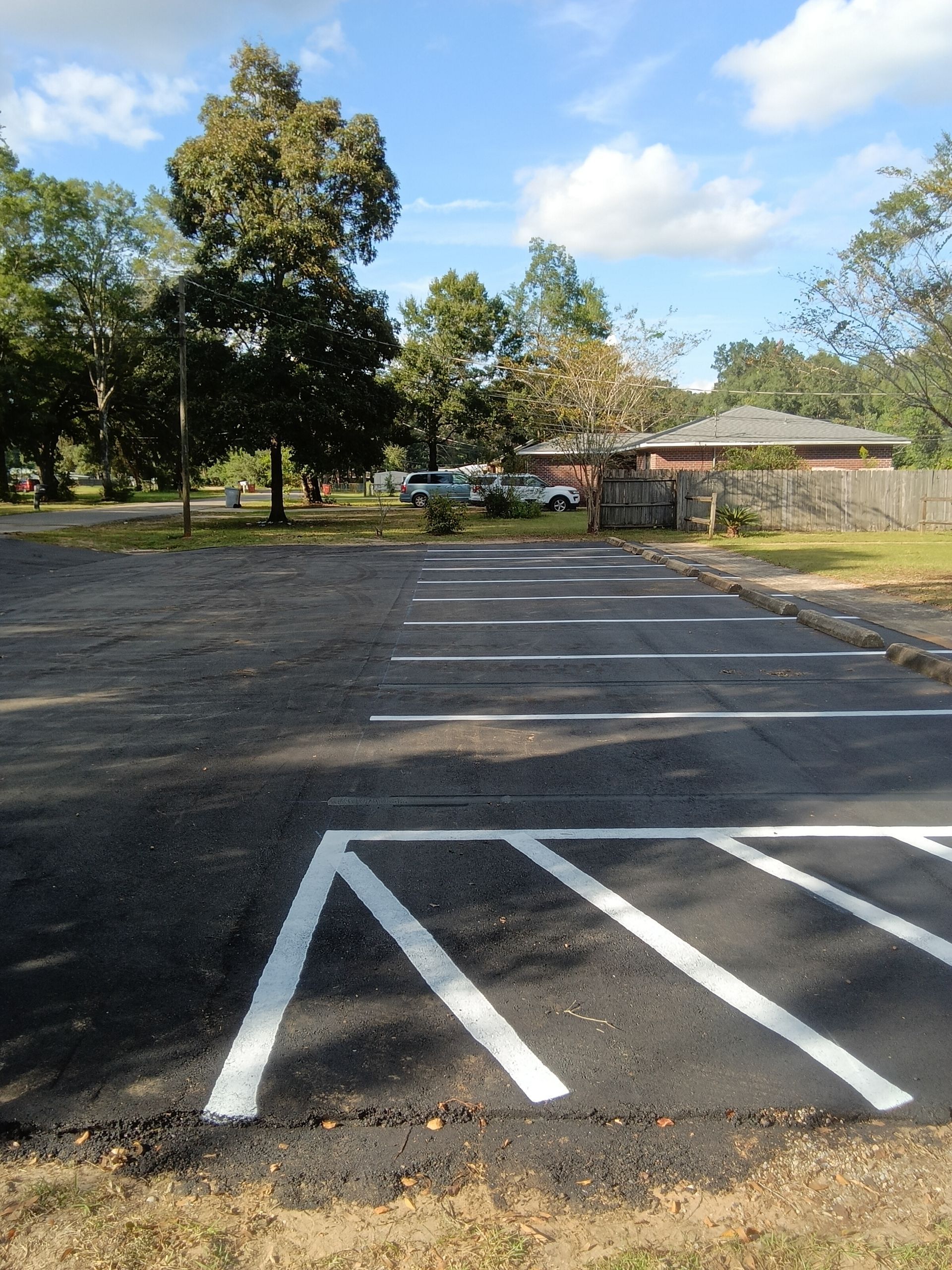 Asphalt parking lot with painted white lines, including a designated handicap spot.