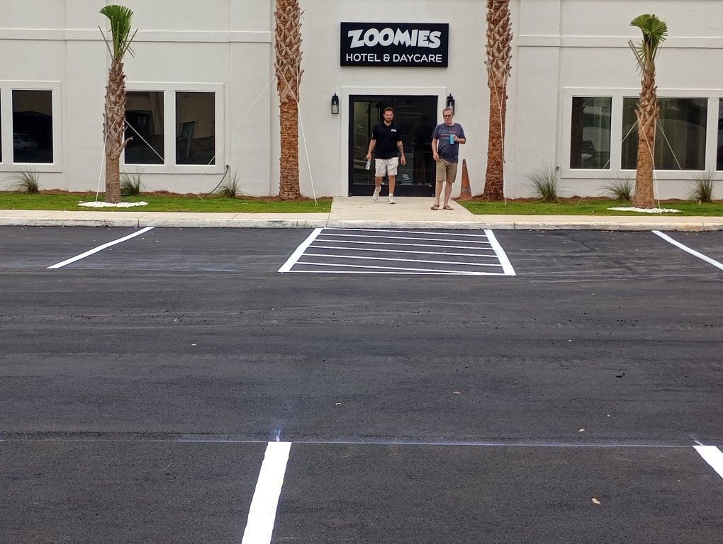 Two men stand at the entrance of Zoomies Hotel & Daycare.