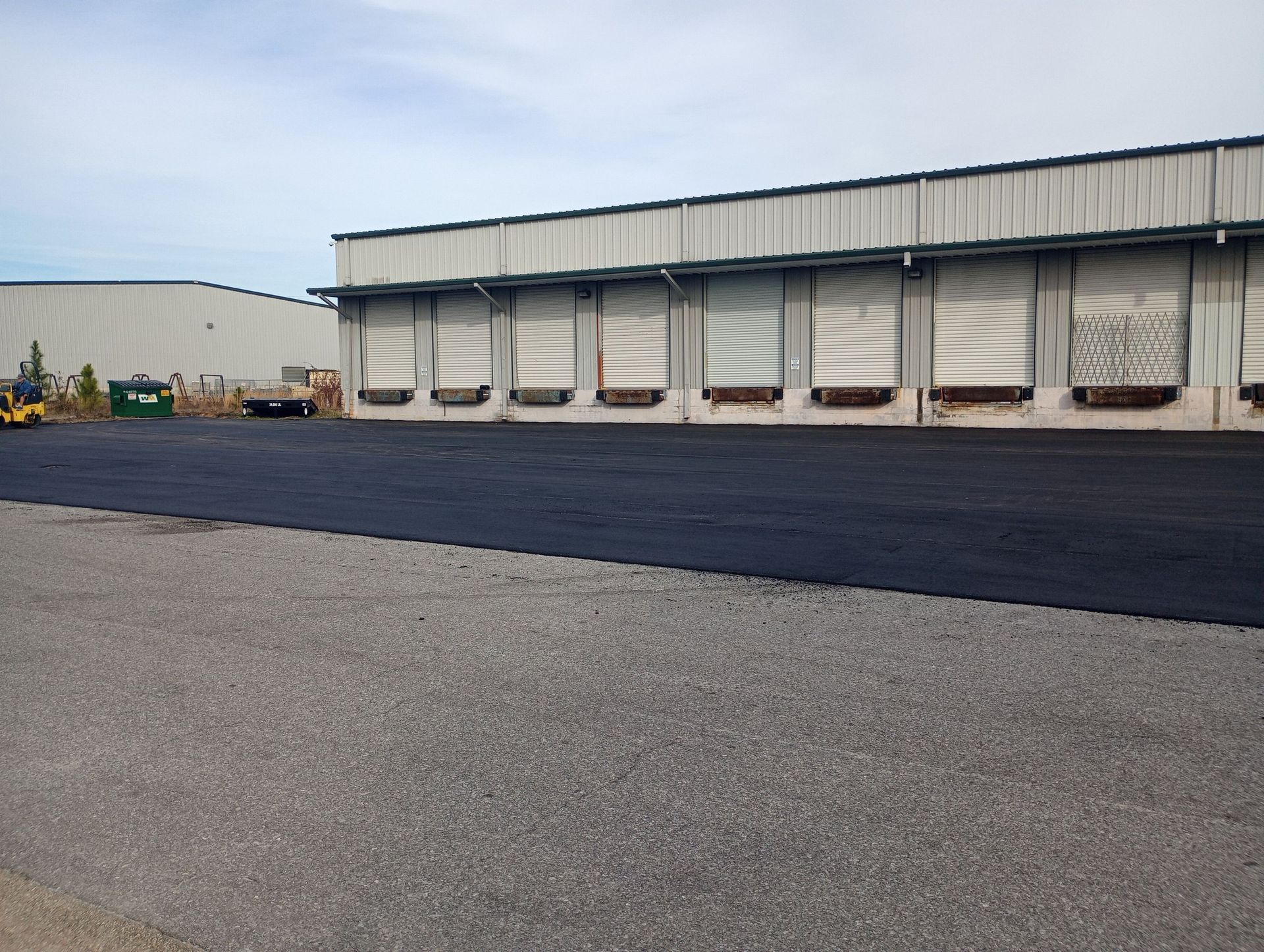 Asphalt parking lot next to a loading dock of a commercial building.
