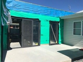 A House with A Screen Door and A Blue Tarp on The Roof — Edwards & Froud Building Services Pty Ltd in Gunnedah, NSW