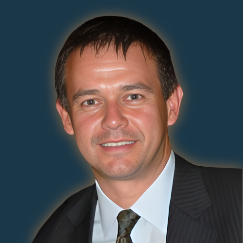 A man in a suit and tie smiles for the camera