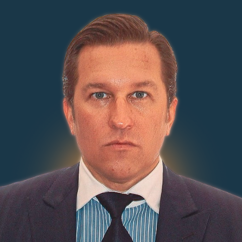 A man in a suit and tie is looking at the camera