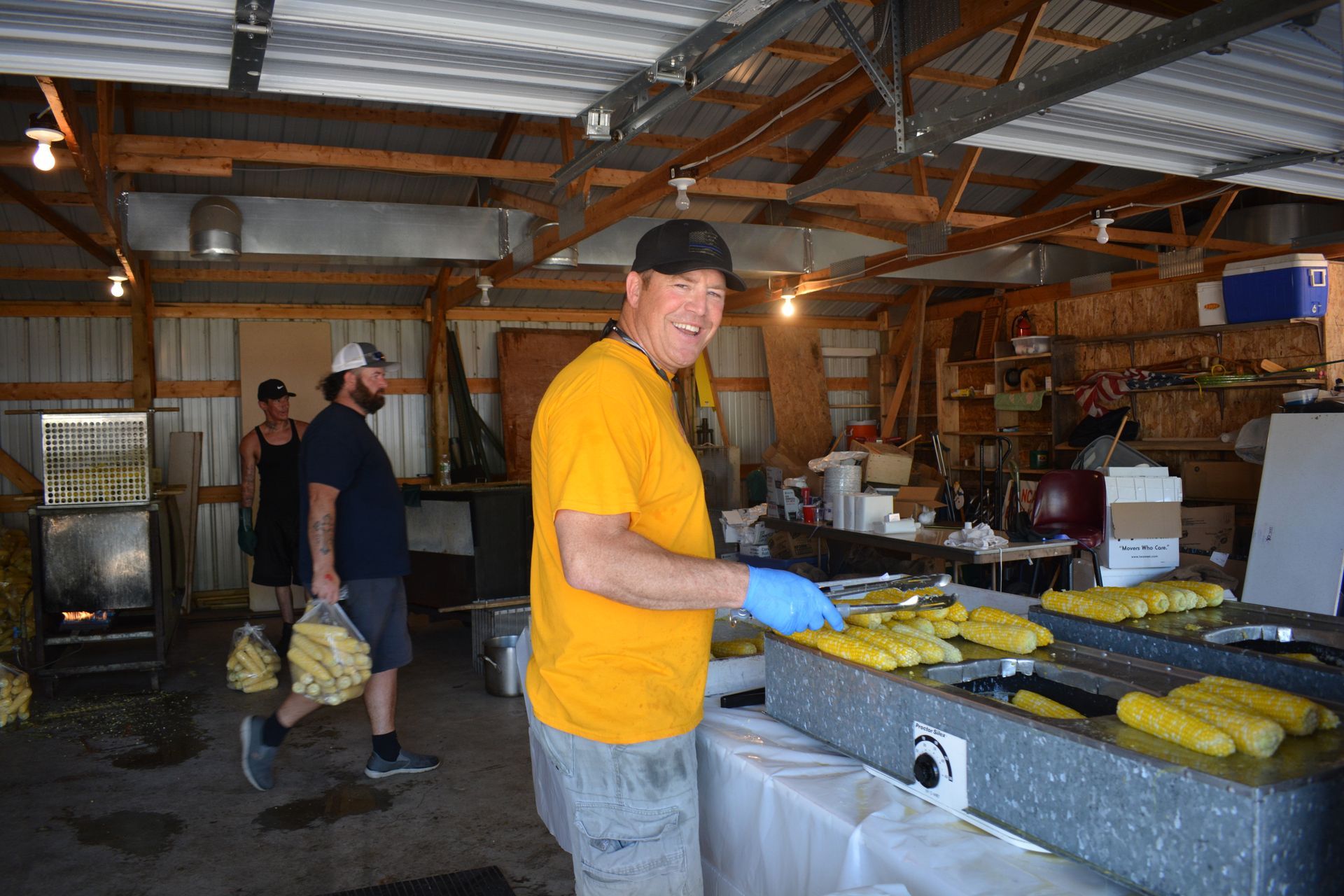 People packing yellow produce on tables in a warehouse-like workspace
