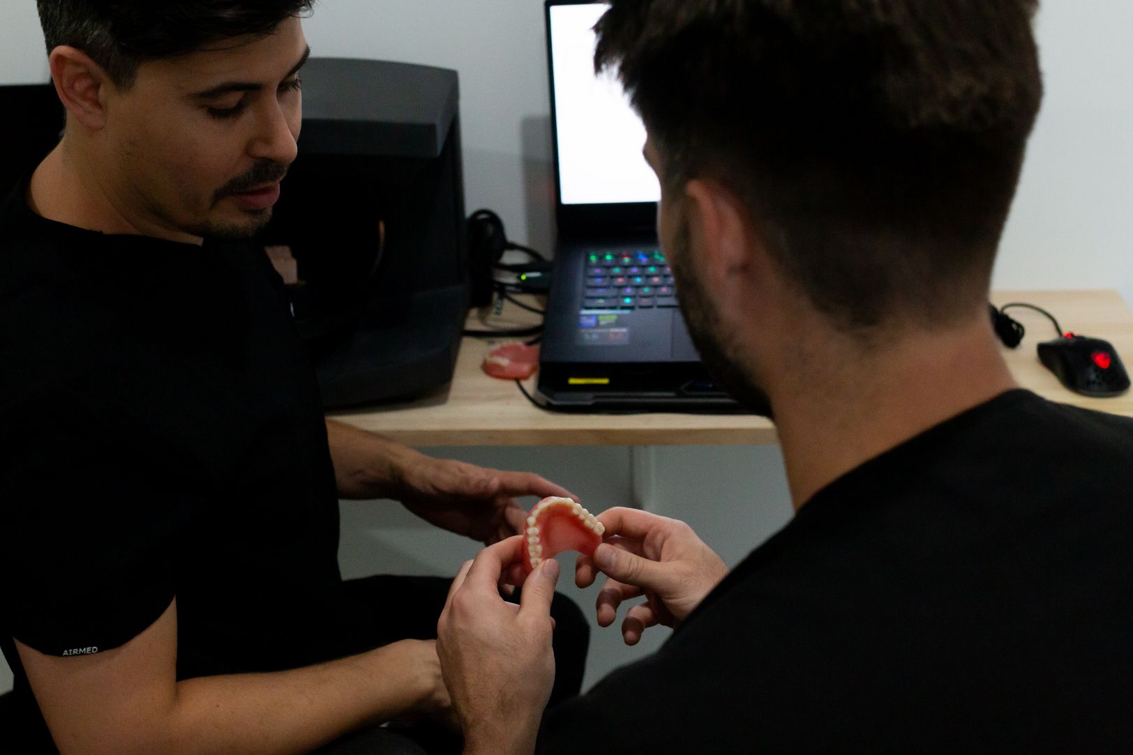 Two Men Examining Dentures in an Office Setting — Dentures Direct Ballina In Ballina, NSW
