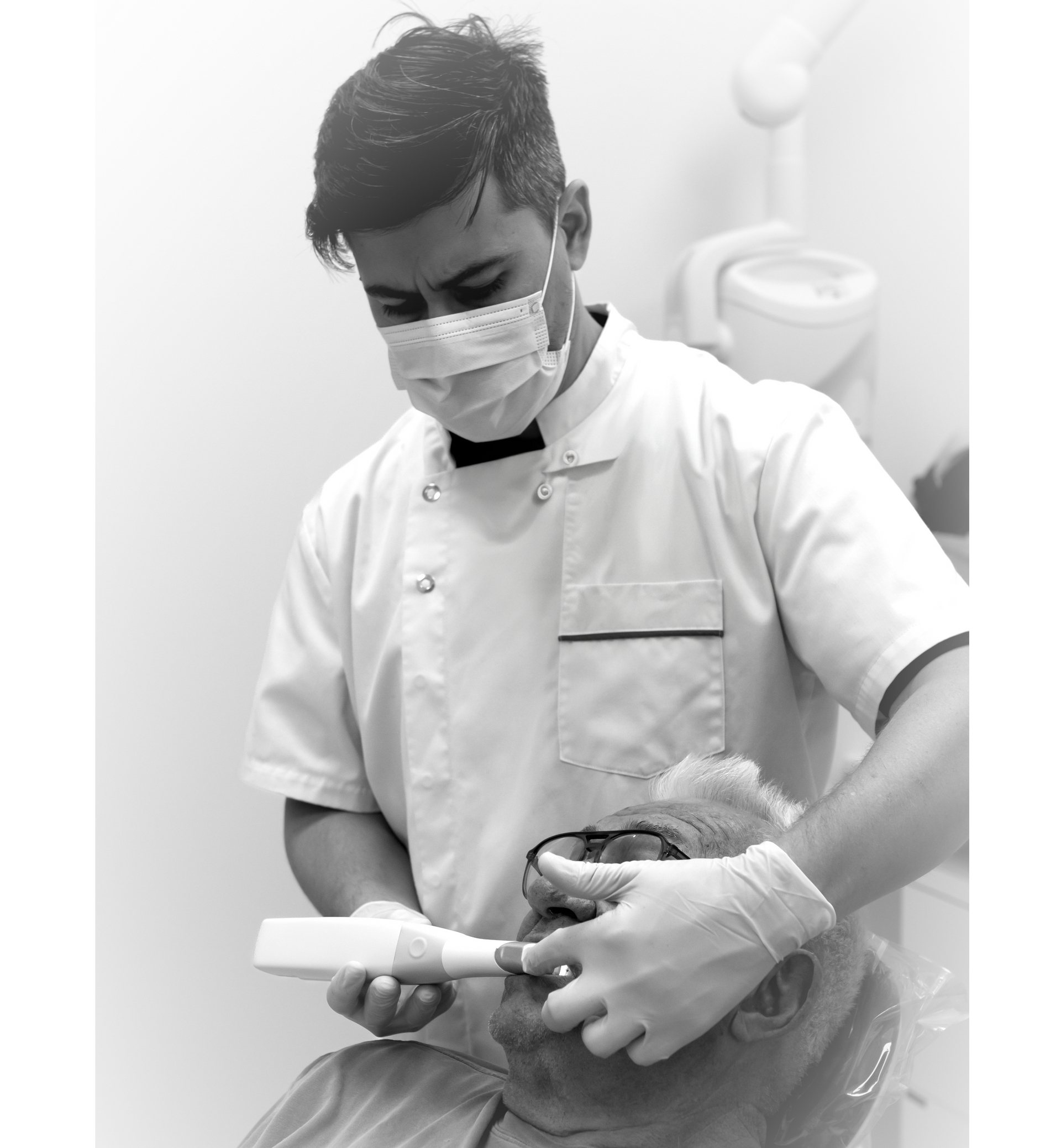 Dentist in mask scans patient's mouth with handheld device. Both are in a dental chair in a clinic.— Dentures Direct Ballina In Ballina, NSW
