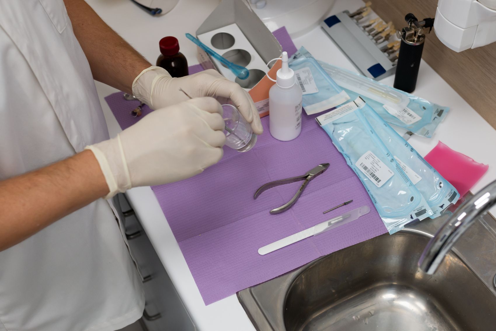 Dentist Wearing Gloves Mixing Dental Materials in a Glass — Dentures Direct Ballina In Ballina, NSW