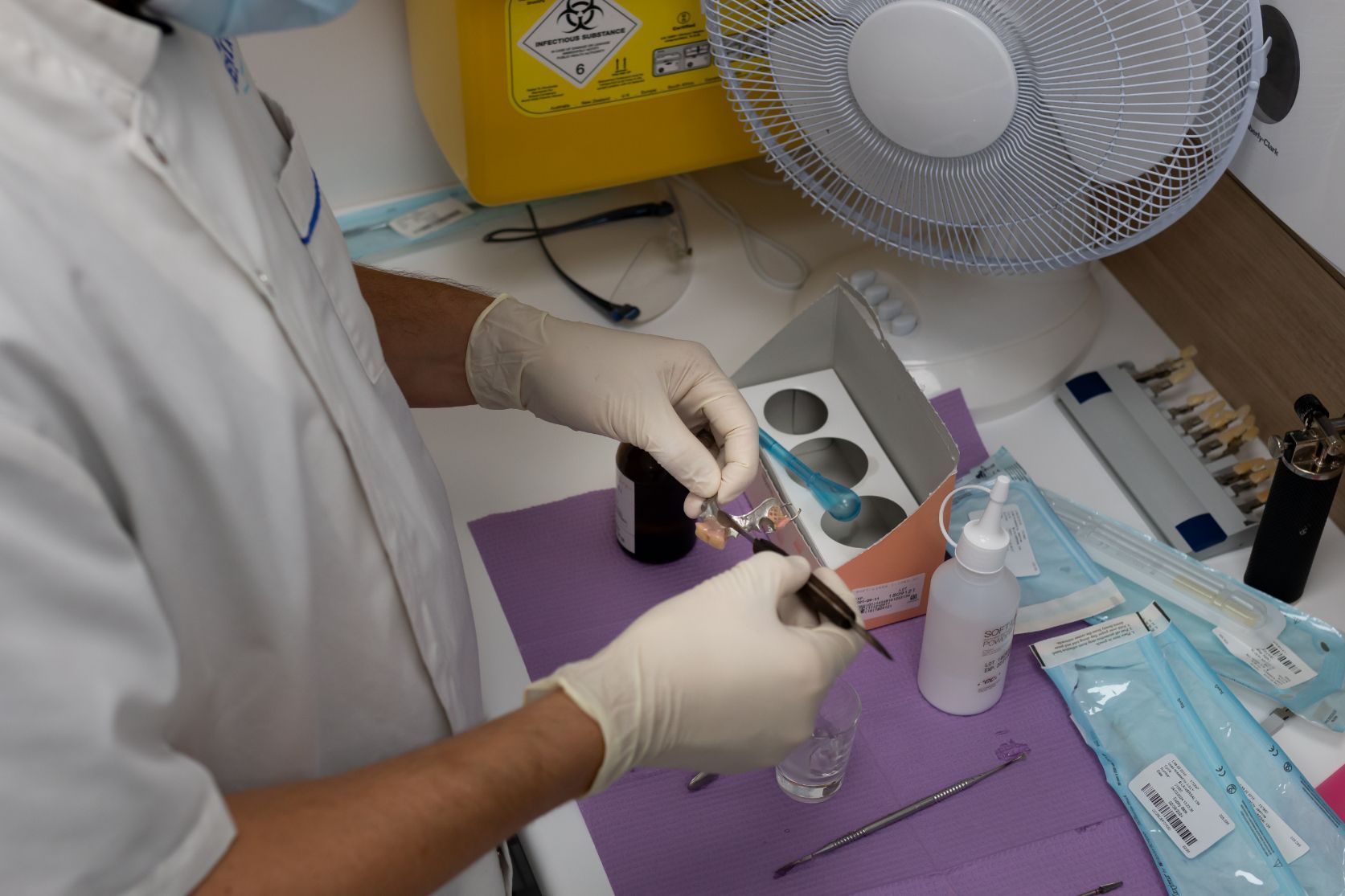 Dentist Wearing Gloves Preparing Tools in a Dental Office — Dentures Direct Ballina In Ballina, NSW