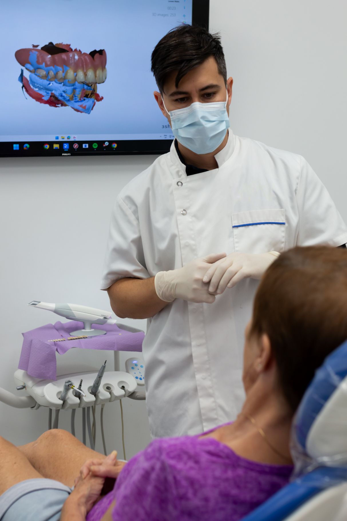 Dentist in Mask Talking to Patient Seated in a Dental Chair — Dentures Direct Ballina In Ballina, NSW