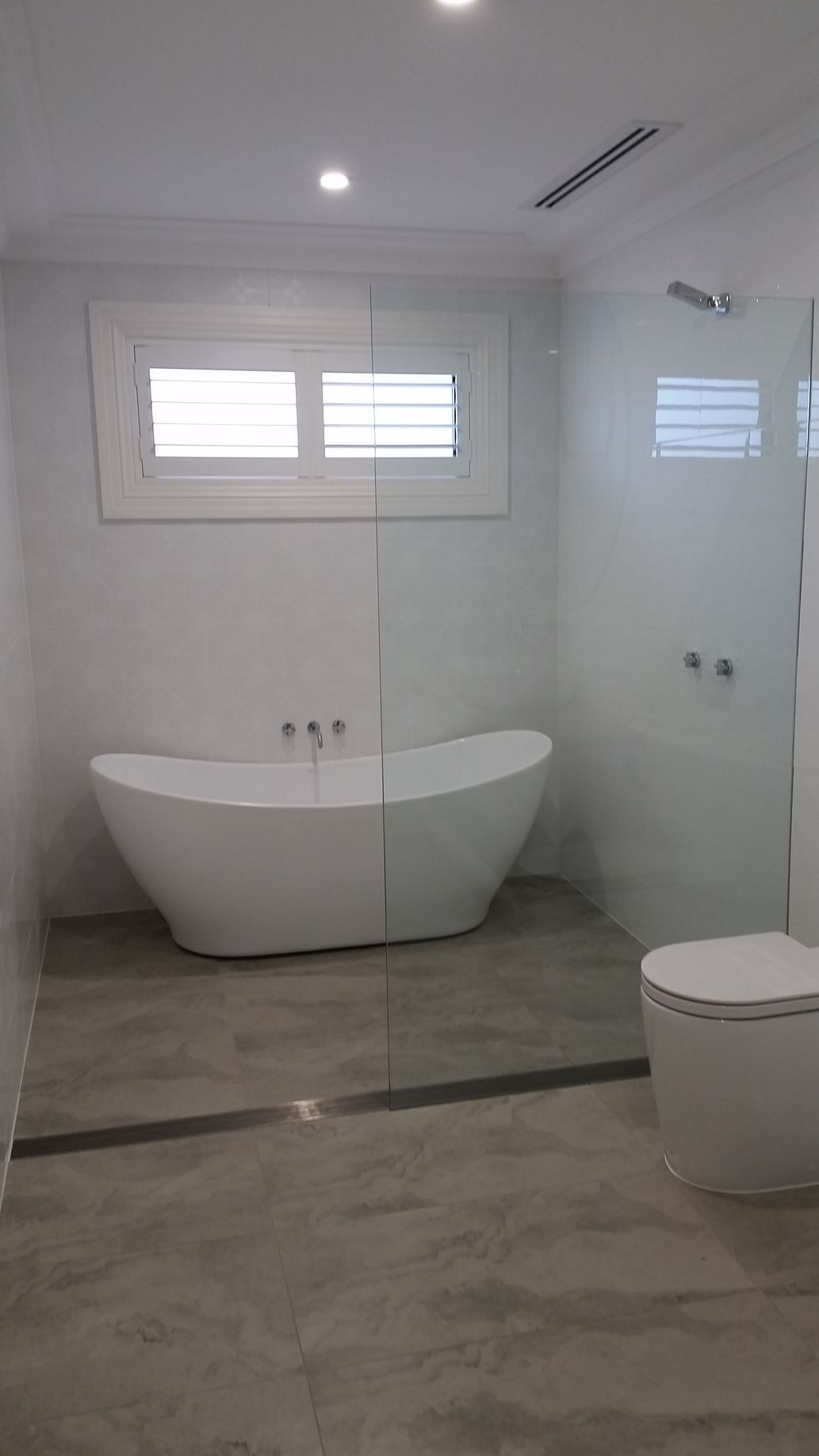 A Man is Fixing a Bathroom Sink With a Wrench — All About Quality Plumbing Services In Halekulani, NSW