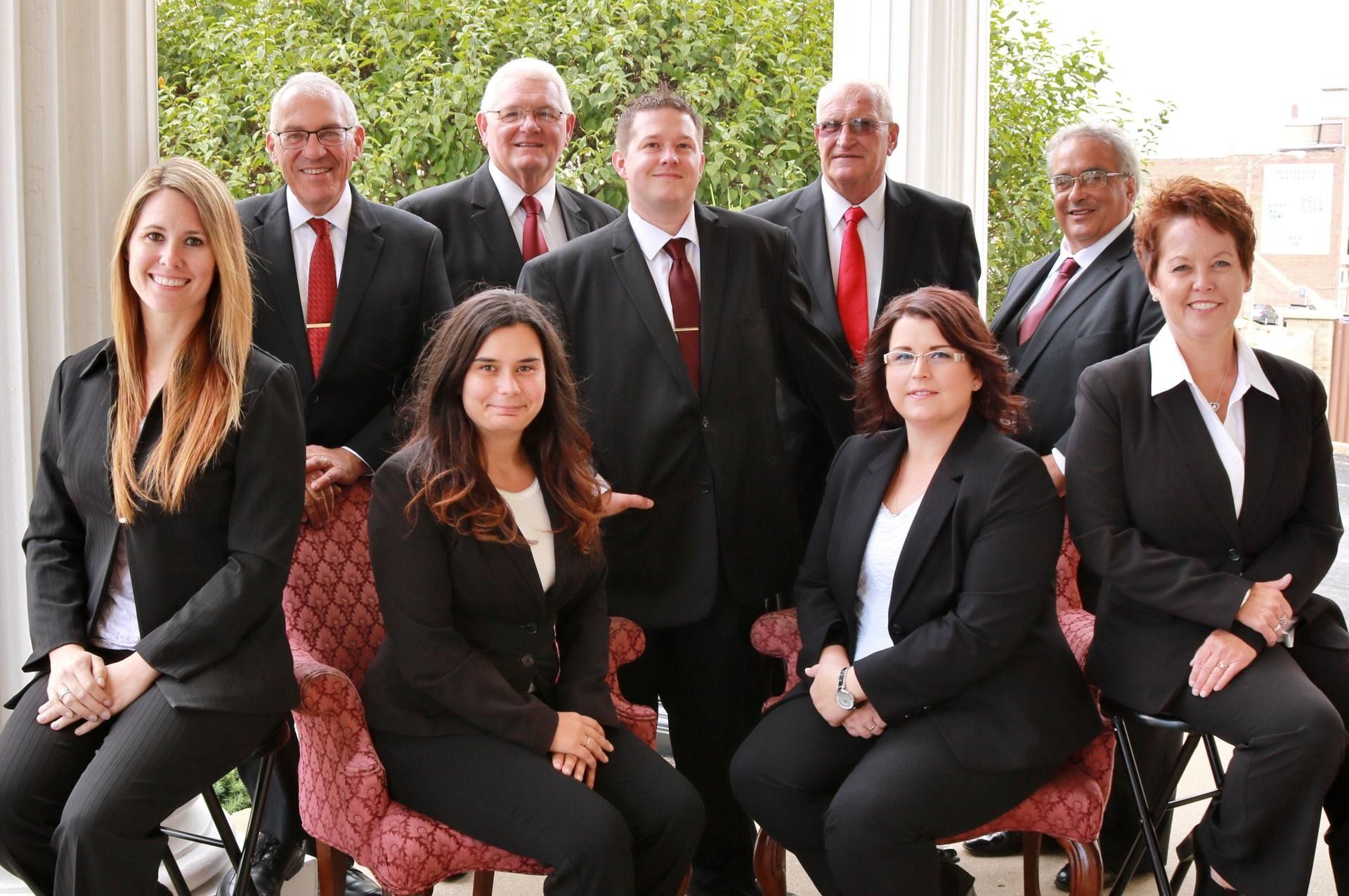 Group of people in business attire posing outdoors.