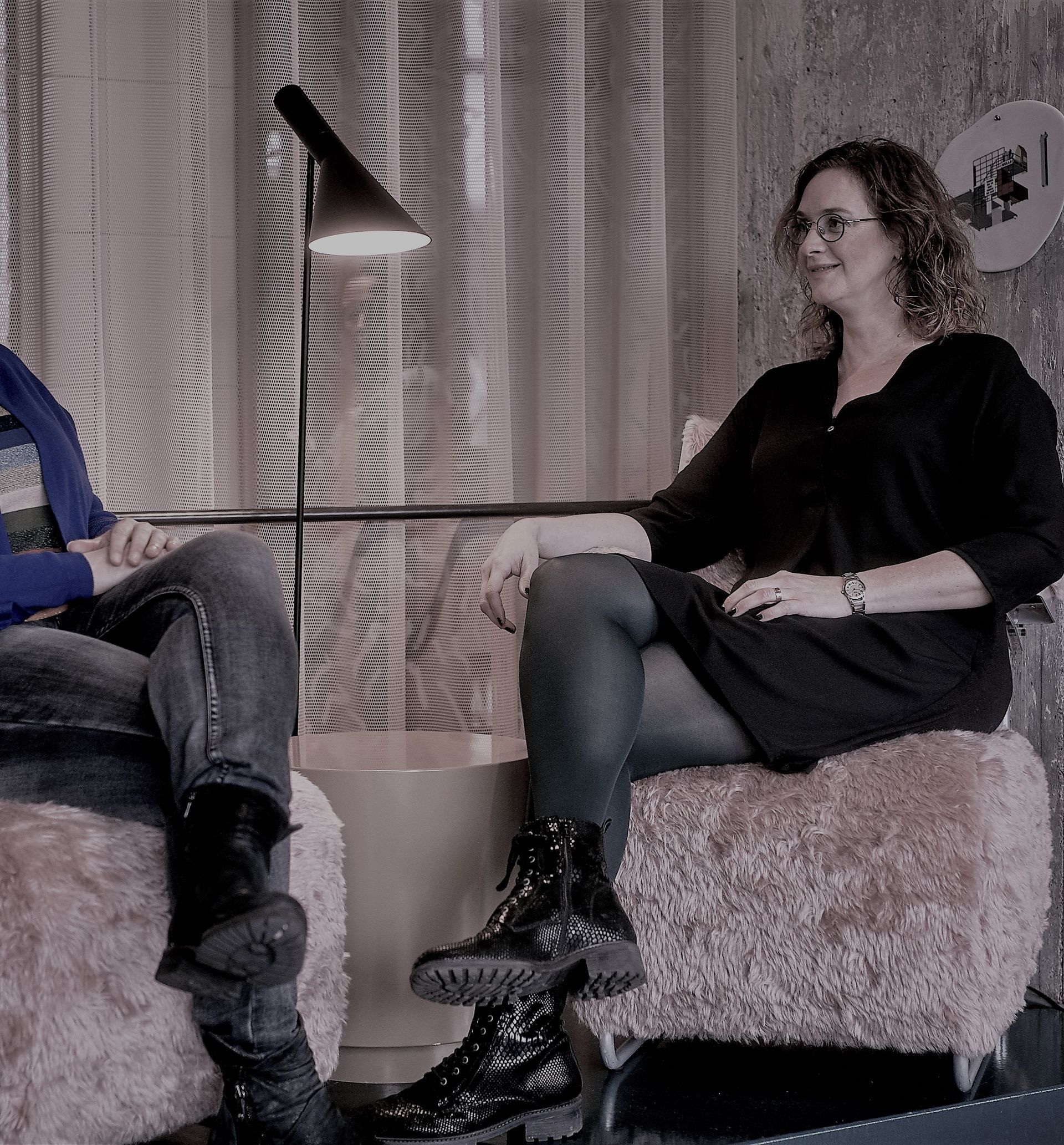 Een man en een vrouw zitten op stoelen met elkaar te praten.