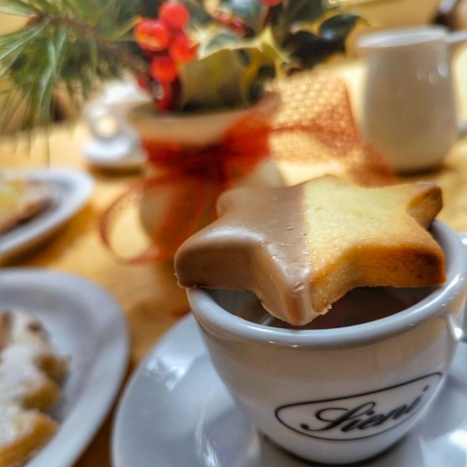 Una tazza di caffè con un biscotto a forma di stella dentro