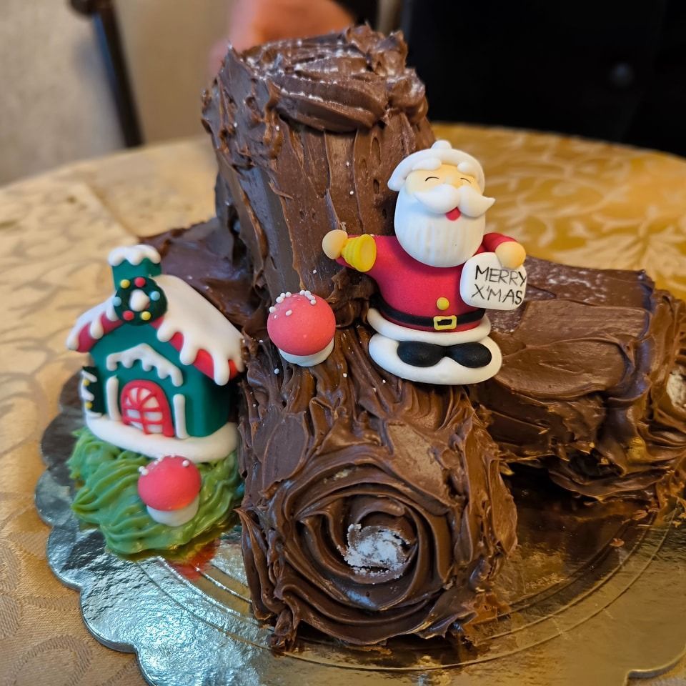 Una torta natalizia con Babbo Natale e una casa sopra